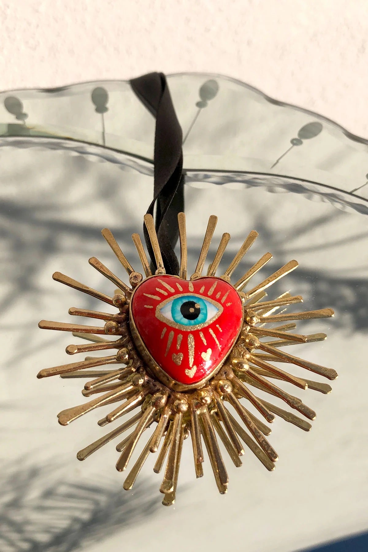 Handmade multicultural necklace in red and gold with an eye in the center.