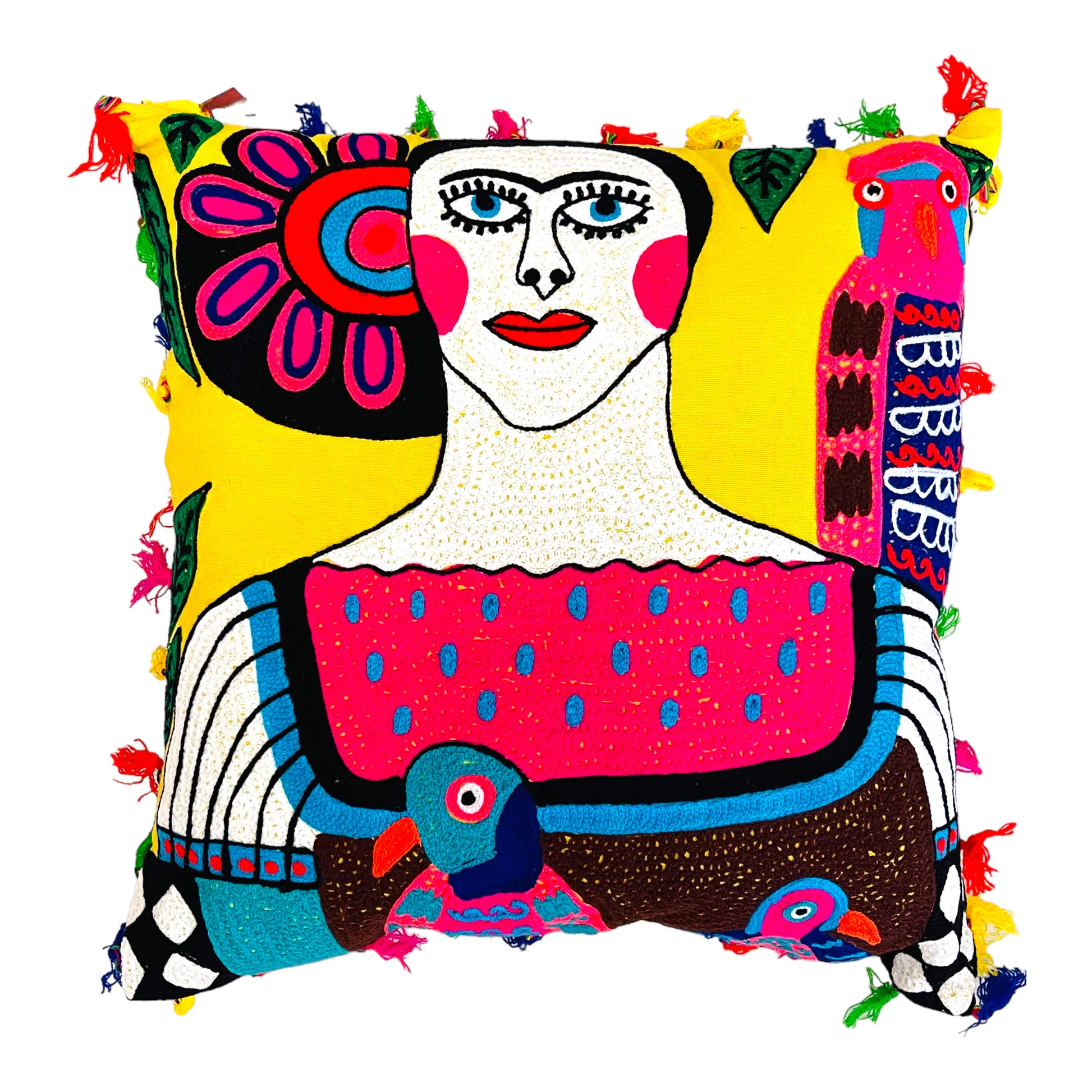 Hand embroidered pillow with an image of Frida Kahlo with picasso graphic style in different colors. It is designed with a parrot on her left shoulder and in the middle of her blouse, the pillow is bordered with pompoms of different colors.