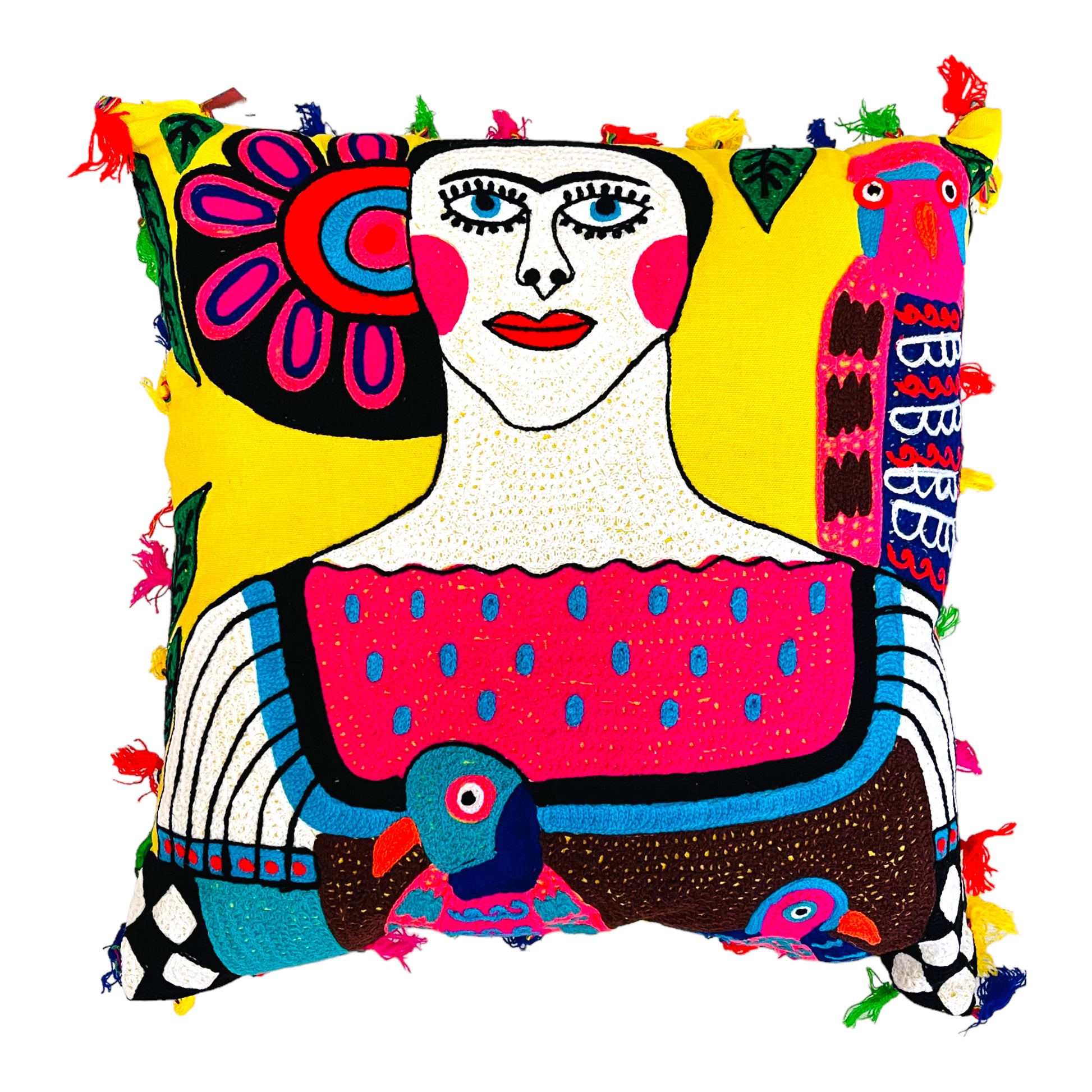 Hand embroidered pillow with an image of Frida Kahlo with picasso graphic style in different colors. It is designed with a parrot on her left shoulder and in the middle of her blouse, the pillow is bordered with pompoms of different colors. 