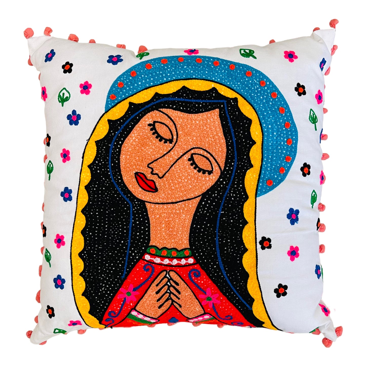 Hand embroidered white pillow with illustration of the virgin Guadalupe in different colors such as yellow, black, red and blue. Around the virgin are embroidered flowers and small green leaves.