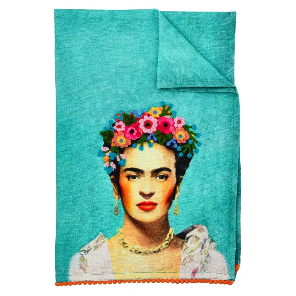 Embroidered teal towel with Frida Kahlo image in the centre. The illustration has a crown of flowers in different colors on her head