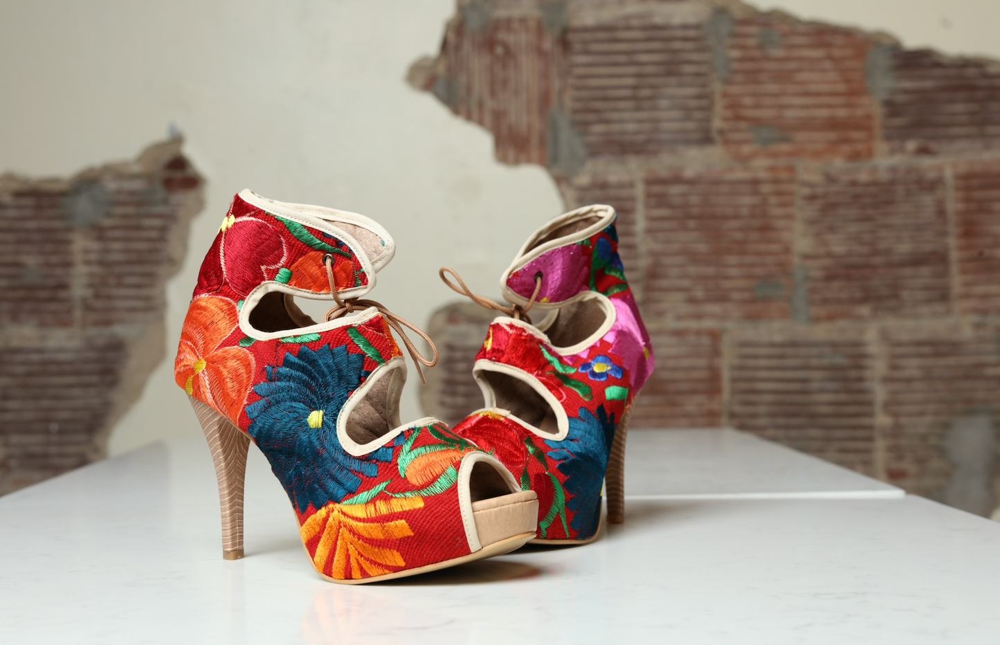High heels with blue, red and yellow floral embroidery.