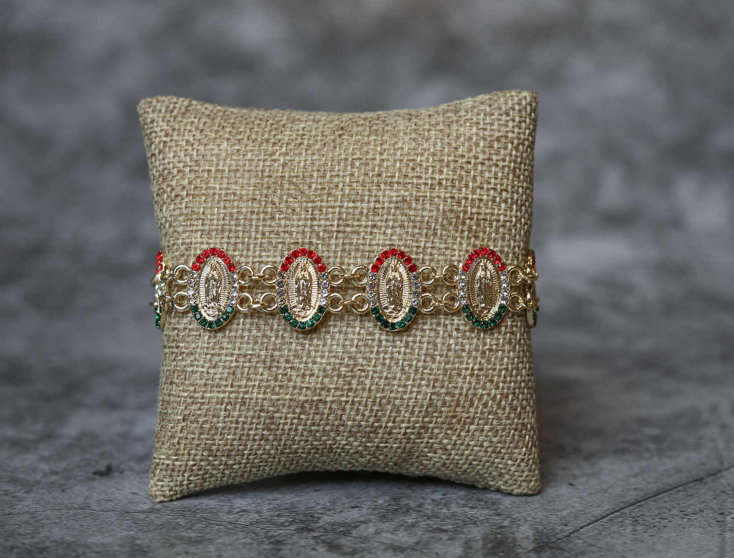 Multicultural oval-shaped gold-plated bracelets of the Virgin of Guadalupe with green and red stones. 