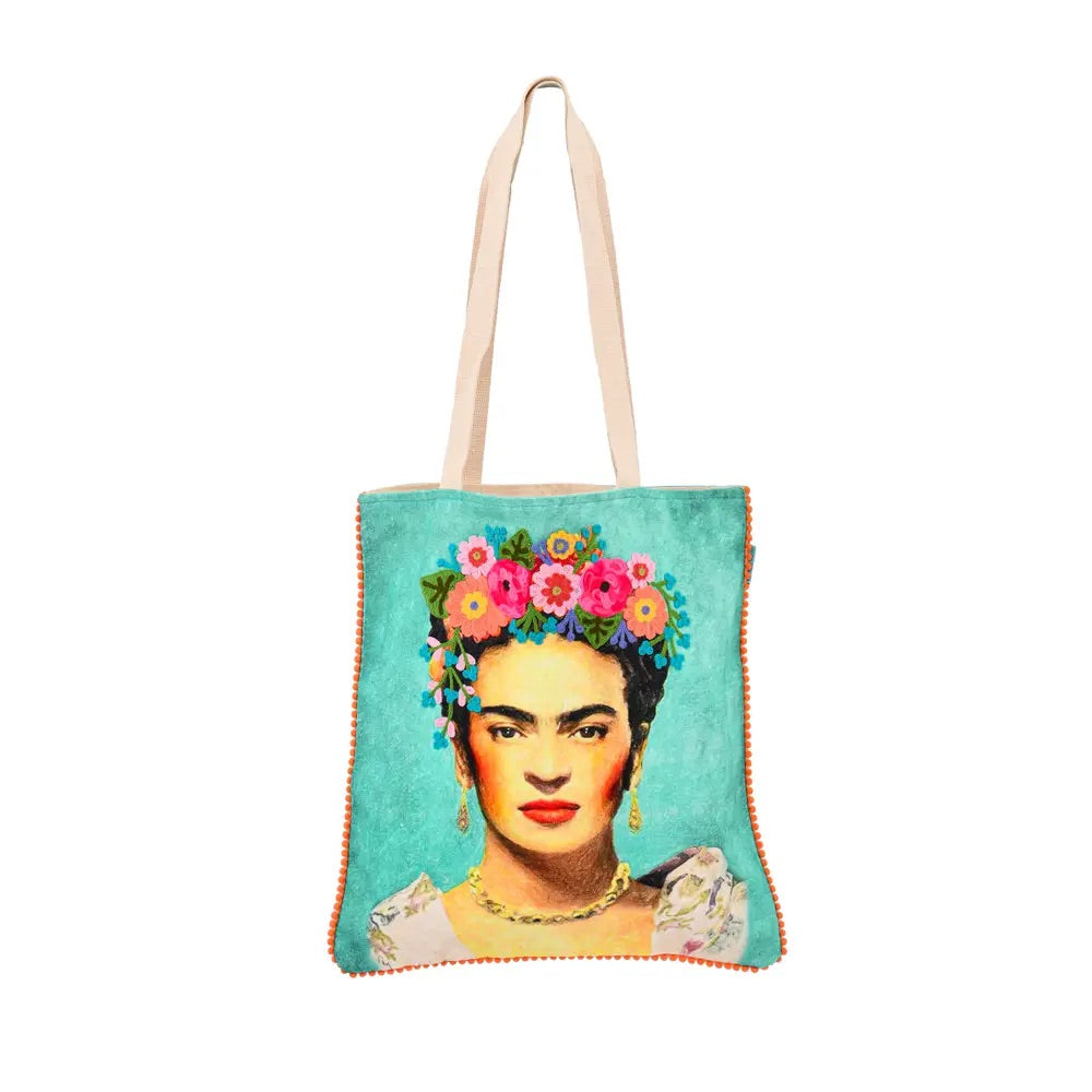 The multicultural teal tote bag has an illustration of Frida Kahlo in the center. She wears golden accessories and on her head a wreath of flowers of different colors. 