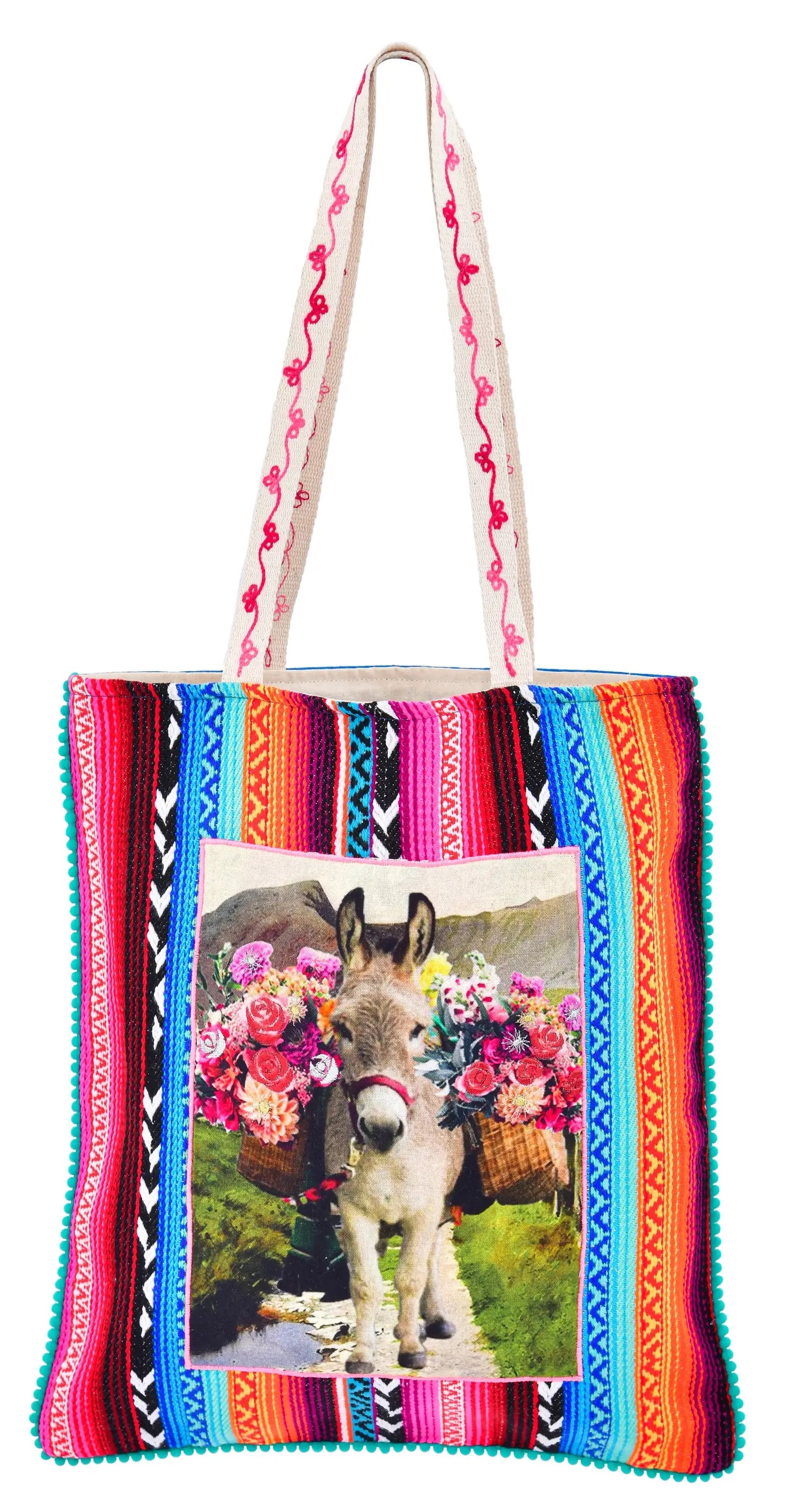 This colorful multicultural tote bag is designed with a drawing of a donkey in the center. The donkey has many flowers and a green mountain behind it.