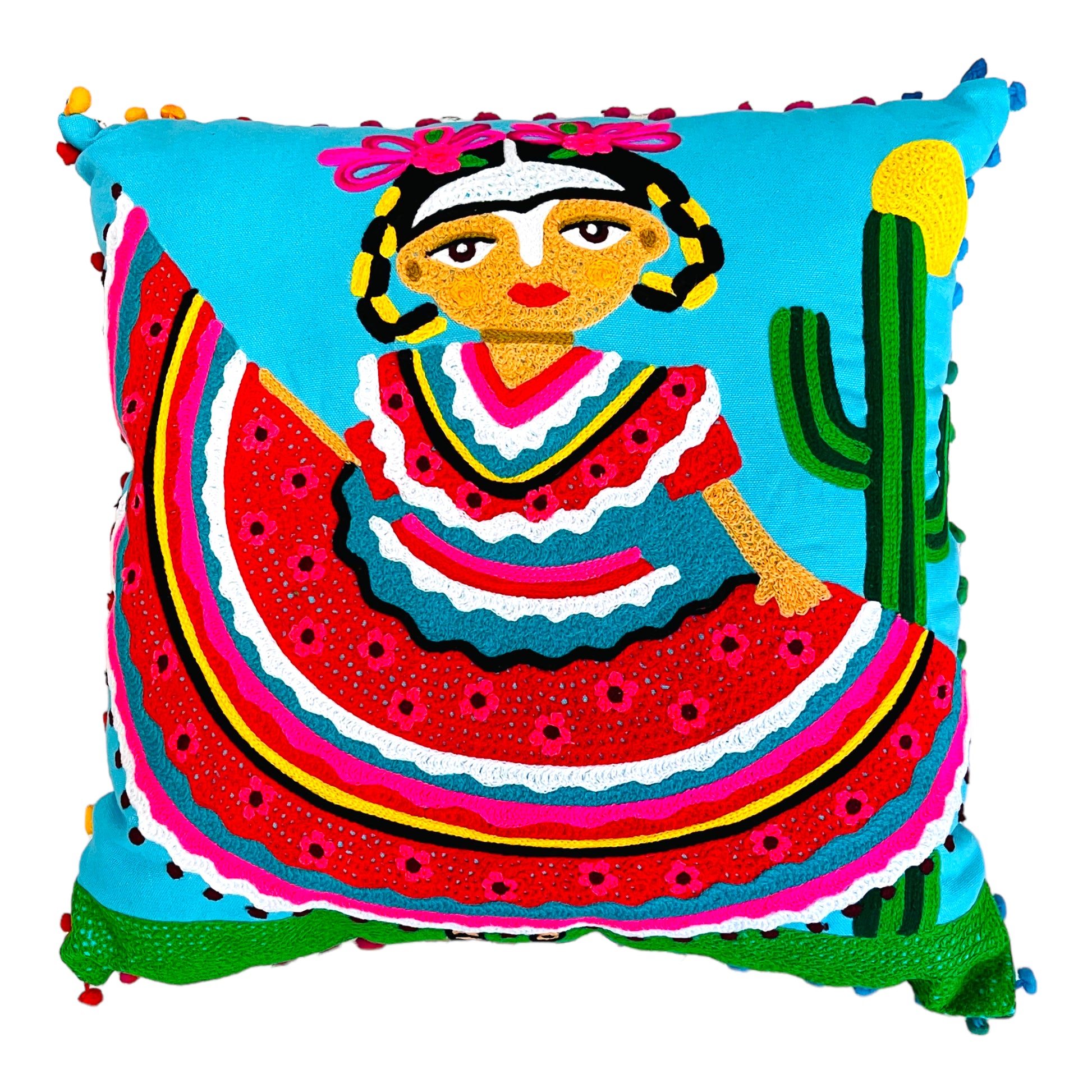 Hand-embroidered light blue pillow with an image of Frida Kahlo dressed in a typical Mexican costume in red, yellow and blue. The border of the pillow is decorated with small blue and red pompons. 